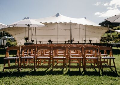 Stretch Tent hire at Mill Creek Cottage with outdoor ceremony padded wooden seats, sun umbrellas, barrel bar leaners