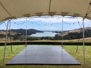 Stretch tents with dance floor overlooking estuarty set up as an event tent or party tent for wedding or party